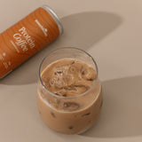 Glass of iced coffee with a can of Protein Coffee on a beige background